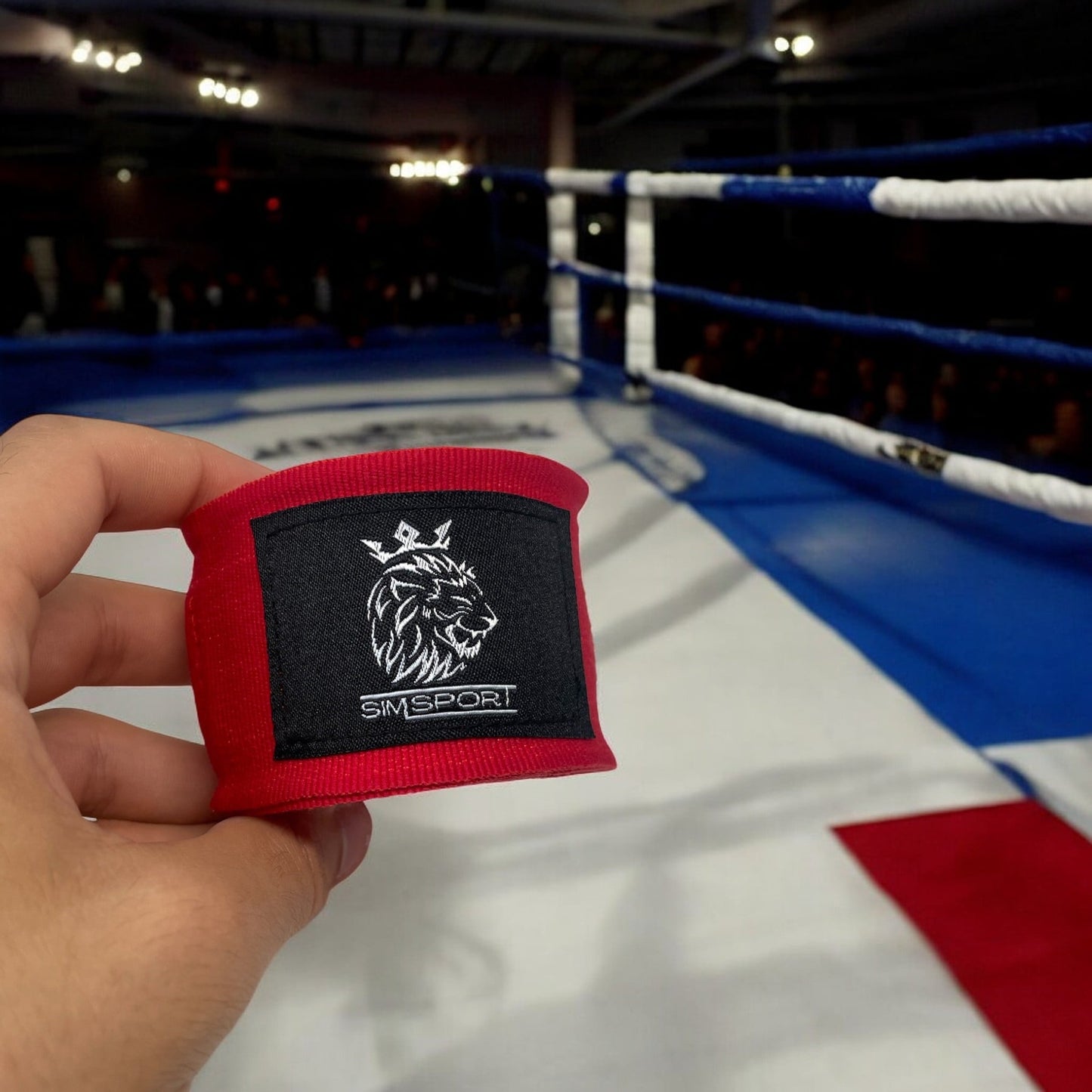Bandes de boxe SIMSPORT couleur rouge portées sur un ring de boxe couleur France, journalistes en arrière plan
