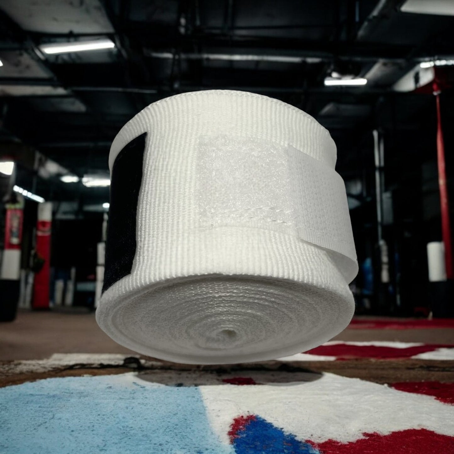Bandes de boxe SIMSPORT couleur blanc posées sur un sol couleur France salle de boxe en arrière plan