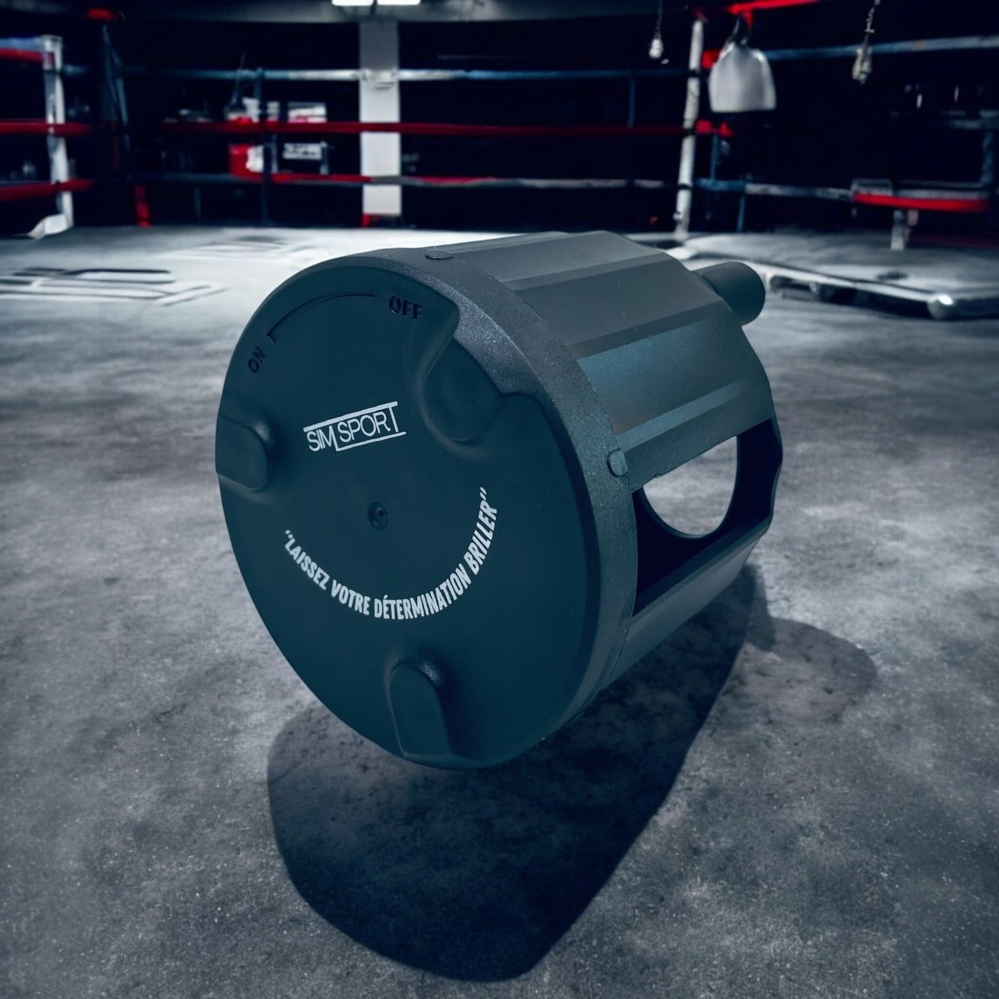 Enrouleur de bandes de boxe dans une salle de boxe sombre, posé sur un sol en béton
